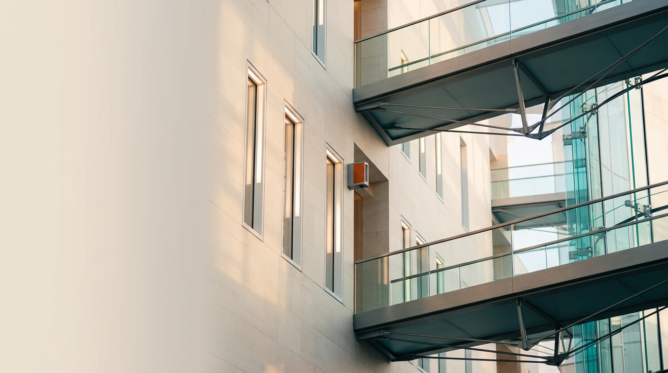 A low-angle, cinematic architectural photograph capturing an elegant, modern atrium space with soaring, interconnected glass and brushed-metal walkways that suggest a smooth, fluid progression of depth. The primary subject is a series of precise, modular lighting apertures embedded into a polished limestone wall, arranged in a refined, rhythmic sequence that directs the eye through the architecture to represent the concept of controlled, scroll-triggered narrative flow. The environment is bathed in soft, warm morning sunlight, with delicate, purposeful rim lighting in deep teal and soft cyan illuminating the glass joints and metal supports to emphasize performance and clarity. A single, restrained accent of warm burnt orange appears as a subtle focal point on a remote architectural sensor module mounted near the center of the frame. The composition is balanced with the intricate structural elements positioned in the right two-thirds, while the left third remains a serene, softly-lit wall surface providing ample negative space for copy. Photographed with a 50mm prime lens, the image displays natural depth of field, realistic metallic material textures, and precise, crisp light without artificial bloom or glow. No humans, no text, no holographic screens, and no artificial data overlays are present. This scene is generated by nanobanana pro --ar 16:9